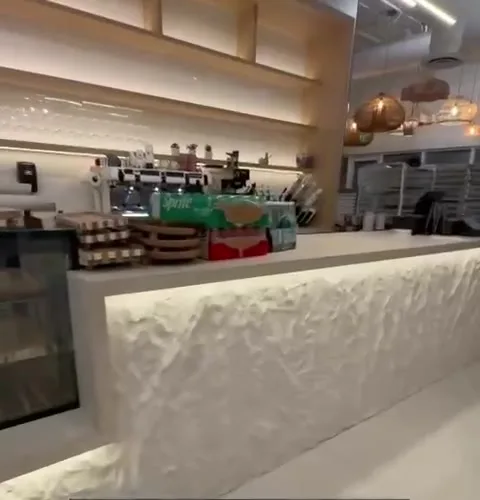 Textured white cafe bar counter with shelf and accent lighting