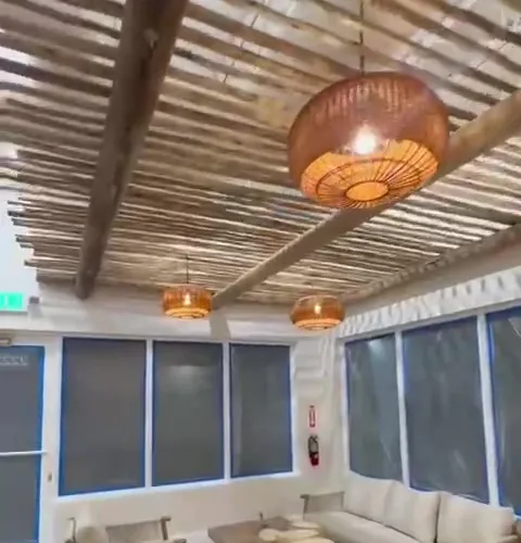 Cafe lounge seating under a slat ceiling with rattan pendant lights