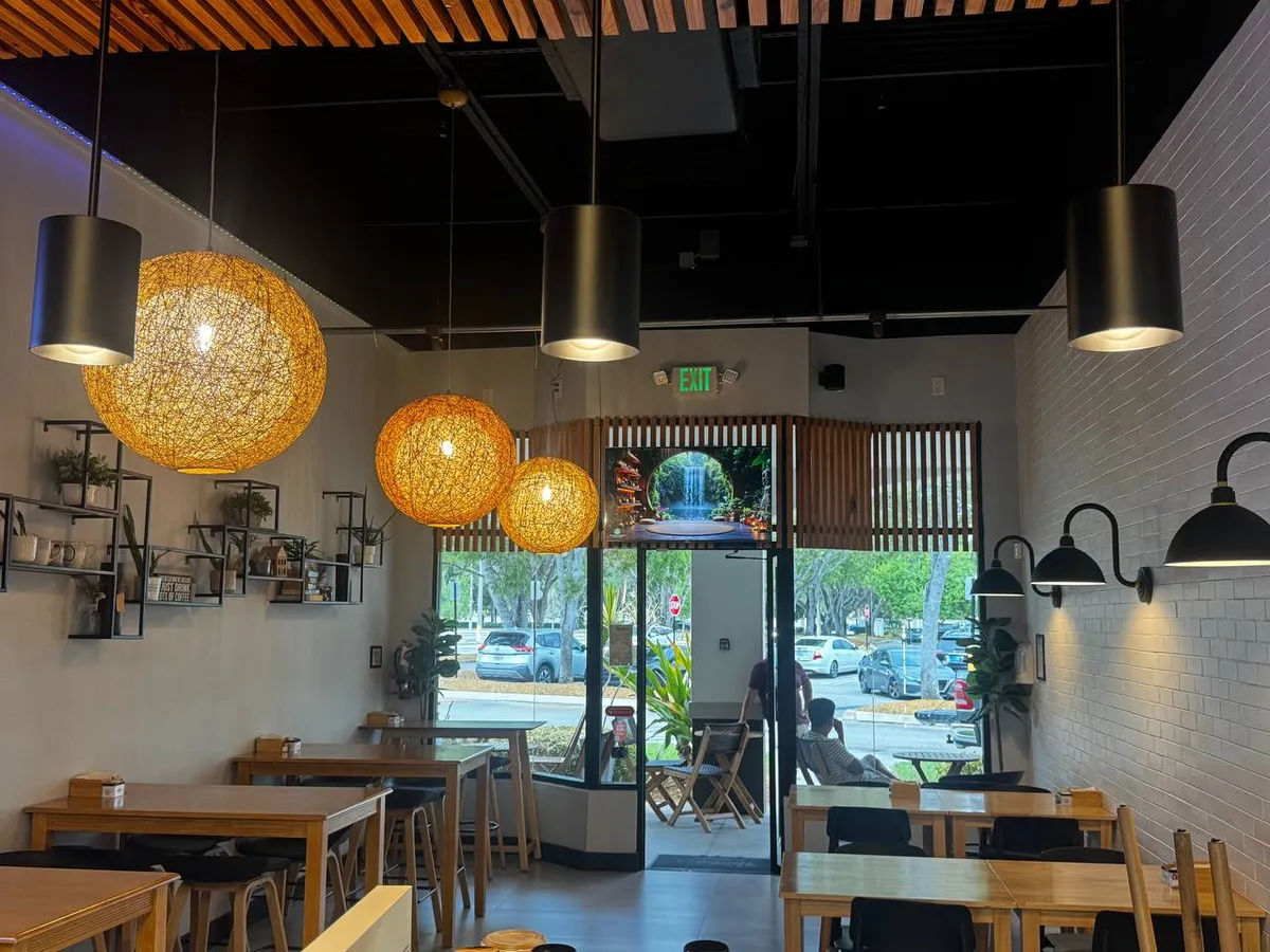 Cafe dining room with rattan globe and black cylinder pendants