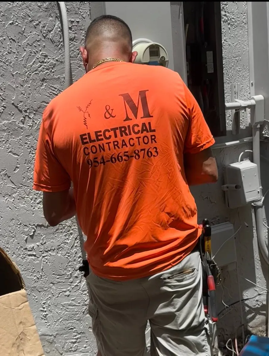 Electrician working on an exterior meter, panel and conduit