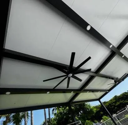 Large outdoor ceiling fan and recessed lights installed under a modern pergola