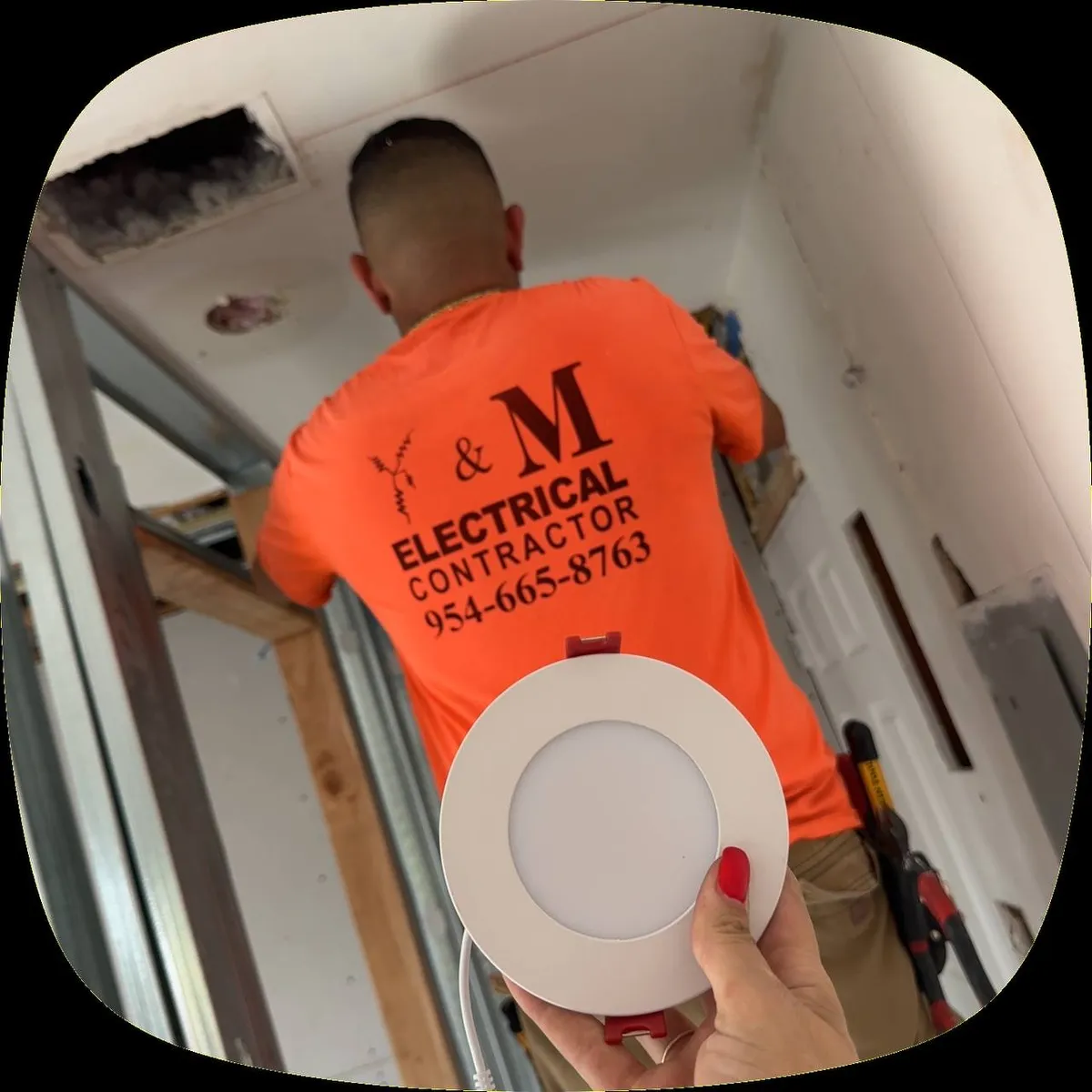 Electrician installing a round recessed LED panel