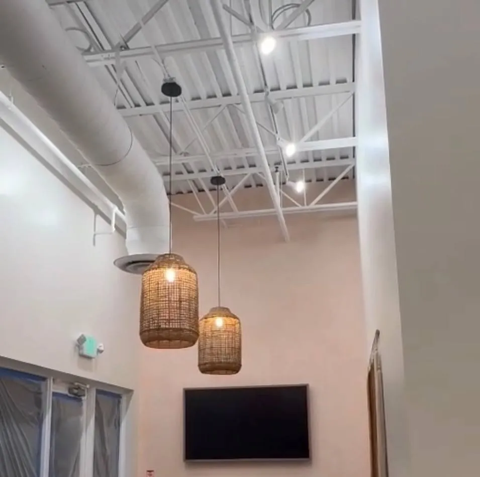 Cage pendant lights beside a wall-mounted TV