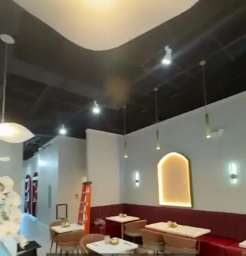 Restaurant dining room with backlit arches, pendant lights and banquette seating