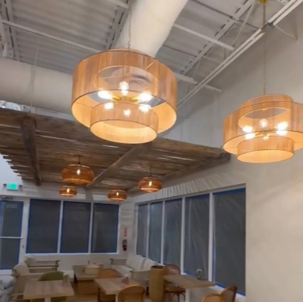 Large rattan drum pendants under a wood slat ceiling