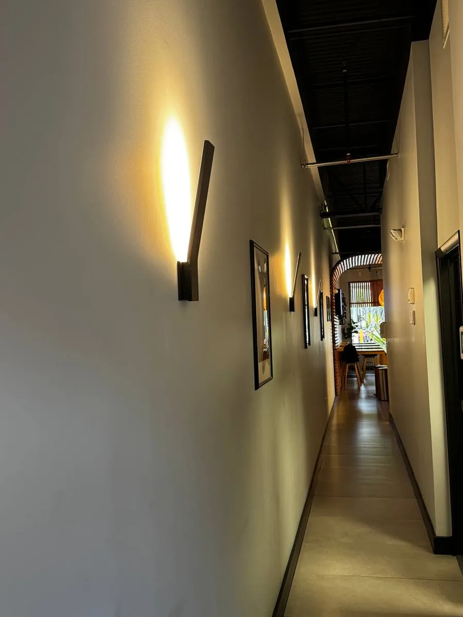 Restaurant hallway lit with modern wall sconces