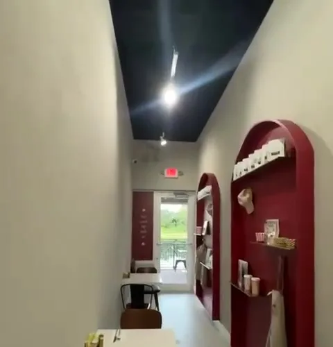 Retail display alcove with red shelving lit by track lights