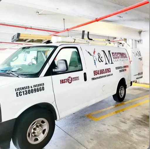 Y&M Electrical Contractor service van in a Miami parking garage